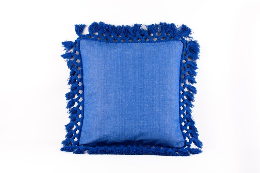 Cojín cuadrado azul intenso con flecos tejidos a mano en los bordes, estilo boho para decoración interior