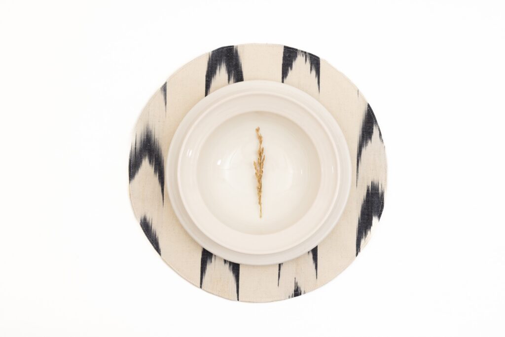 Salvamantel redondo de Teixits Vicens en diseño de llengües blanco y negro, ideal para mesa con estilo artesanal