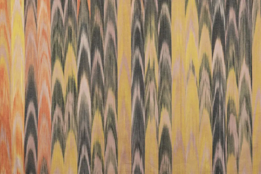 Tejido ikat mallorquín en tonos amarillos, naranjas y negros con patrón de lenguas tradicional
