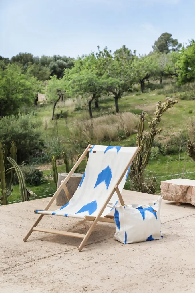 Hamaca y bolsa con diseño textil mallorquín azul de Teixits Vicens en jardín rústico